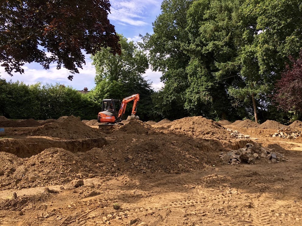 Digger on site levelling the landscape during construction.